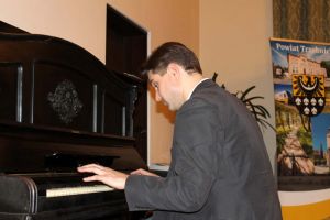 Stanislav Soloviev playing on the antique piano located in a Hall of the District Office in Trzebnica. Photo by Jowita Małogoska.